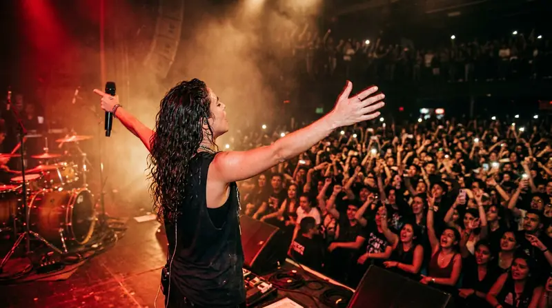 La misma artista del principio, frente a un público con las manos arriba.